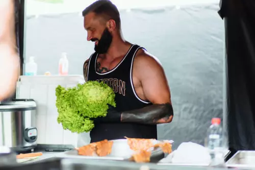 Ein Koch mit eine Salatkopf in der Hand